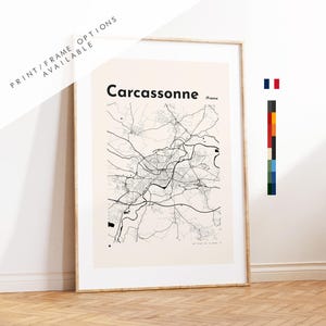 May include: A framed wall art print featuring a black and white map of Carcassonne, France, set against a light beige background. The map displays intricate black line work representing city streets and roads, with the text Carcassonne /France.