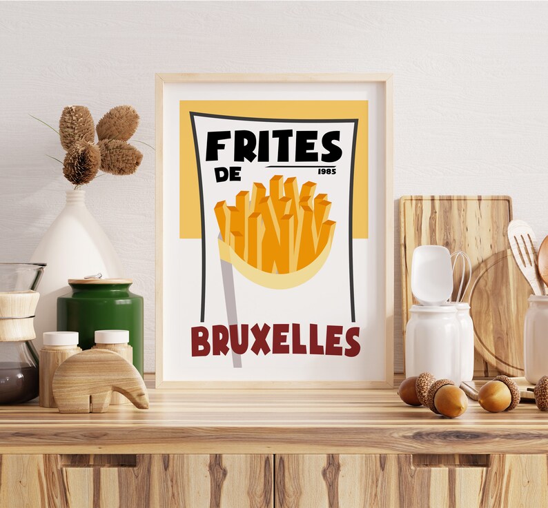 Puede incluir: Un p&oacute;ster de estilo vintage con fondo amarillo y texto rojo y negro. El p&oacute;ster dice "Frites de Bruxelles 1985" y presenta una imagen de dibujos animados de una bolsa de papel de patatas fritas.