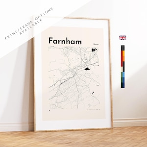 Könnte beinhalten: Ein gerahmter Kunstdruck mit einer schwarzen Linienkarte von Farnham, Surrey, auf hellbeigem Hintergrund. Der Text lautet Farnham und Surrey. Eine kleine britische Flagge und ein vertikaler Farbpalettenstreifen sind rechts zu sehen.