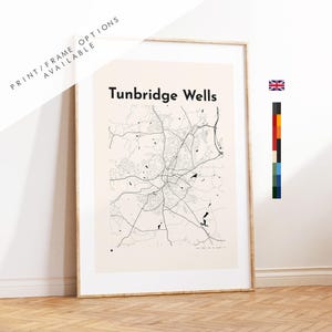 Può includere: Una stampa artistica incorniciata con una mappa a linee nere di Tunbridge Wells su sfondo beige chiaro. Il testo Tunbridge Wells è stampato in nero nella parte superiore. La stampa include una piccola icona della bandiera britannica e una barra.