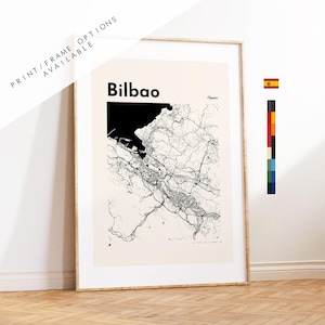 May include: A framed wall art print featuring a black and white map of Bilbao, Spain. The map displays intricate street networks and a large black area representing the water. The text reads Bilbao and /Spain in a clean, bold, black font.