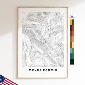 May include: A framed topographic map print of Mount Darwin featuring black contour lines on a white background. The text reads MOUNT DARWIN, 37.1676 N, 118.4729 W, 4218m. A vertical color palette strip and a small California state flag icon are included.