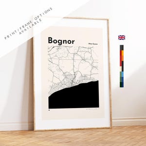 Könnte beinhalten: Ein gerahmter Kunstdruck mit einer minimalistischen Karte von Bognor, West Sussex. Das Design zeigt schwarze Straßenlinien auf cremefarbenem Hintergrund mit einer massiven schwarzen Fläche, die die Küste darstellt. Der Text Bognor und West Sussex ist aufgedruckt.