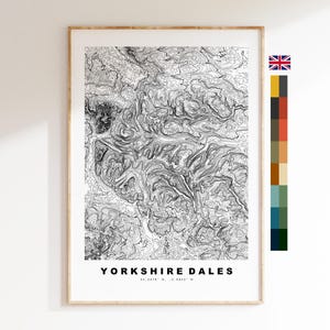 May include: A framed black and white topographic map print of the Yorkshire Dales. The print features contour lines and the text "Yorkshire Dales" at the bottom. The frame is a light wood color.
