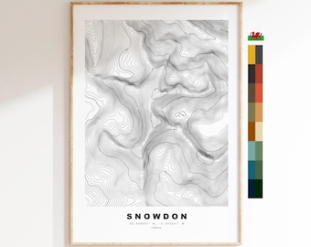 May include: A black and white topographic map print of Snowdon, a mountain in Wales. The print features contour lines and the text "Snowdon 53.048497° N, 4.074231° W 1085m".