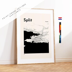 May include: A framed wall art print featuring a minimalist map of Split, Croatia. The design displays black street lines and solid black water areas against a light beige background. The text reads Split and Croatia, with coordinates at the bottom.