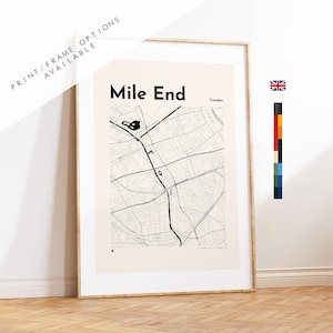 May include: A framed wall art print featuring a minimalist black and white map of Mile End, London. The design displays street layouts on a light beige background with the text Mile End and /London. A small British flag and color palette are visible.