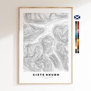 May include: A framed topographic map print featuring black contour lines on a white background. The text CISTE DHUBH, 57.1993°N, -5.2096°W, and 979m is printed at the bottom. A small Scottish flag and a vertical colour palette are on the right.