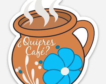 Könnte beinhalten: Eine braune Keramiktasse mit einem blauen Blumendesign und weißen Akzenten. Die Tasse ist mit brauner Flüssigkeit gefüllt und es steigt Dampf aus ihr auf. Der Text "¿Quieres Café?" ist auf die Tasse geschrieben.