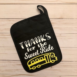 May include: Black oven mitt with a white design that says "THANKS for the SWEET RIDE" and a yellow school bus illustration.