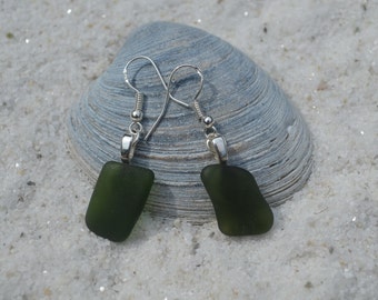 May include: A pair of dangle earrings with dark green sea glass and silver hooks.