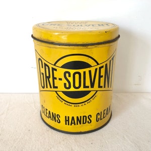May include: Yellow metal tin with black lettering that reads "GRE-SOLVENT TRADE MARK REG. U.S. PAT. OFF. CLEANS HANDS CLEAN".