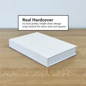 May include: A white hardcover book with the text "Real Hardcover" on the front cover. The text below reads "no dust jacket, bright clean design crisp neutral for warm and cool spaces".