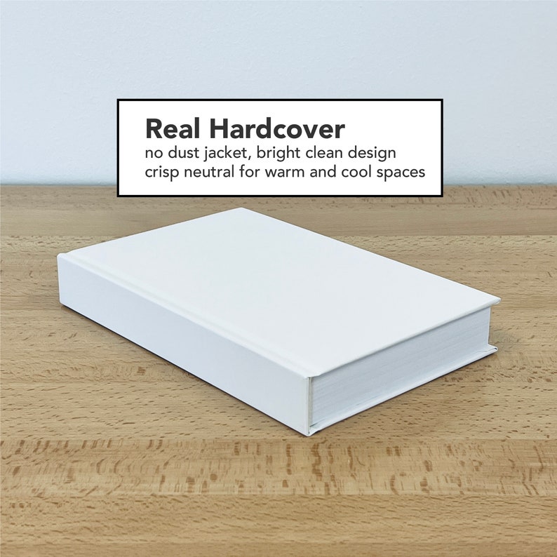 May include: A white hardcover book with the text "Real Hardcover" on the front cover. The text below reads "no dust jacket, bright clean design crisp neutral for warm and cool spaces".
