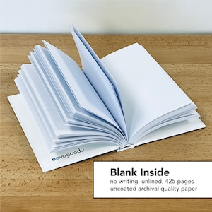 Puede incluir: Un cuaderno blanco en blanco con 425 p&aacute;ginas sin l&iacute;neas. El cuaderno est&aacute; abierto para mostrar las p&aacute;ginas en blanco y el texto "Blank Inside" est&aacute; impreso en la parte inferior de la imagen.
