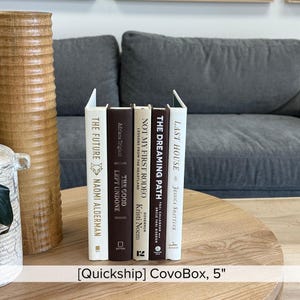 May include: A collection of five books with various titles and authors, including "The Future" by Naomi Alderman and "Last House" by Jessica Shattuck. The books are arranged on a wooden table. The text "[Quickship] CovoBox, 5" is visible.