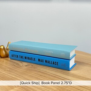 May include: Two decorative book panels stacked on a wooden surface. The top book is light blue with gold lettering, and the bottom book is blue with white lettering. The text "AFTER THE MIRACLE MAX WALLACE" is visible. The depth is 2.75 inches.
