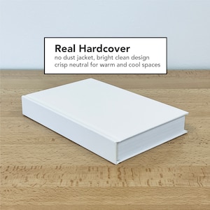 May include: A white hardcover book with the text "Real Hardcover" on the front cover. The text below reads "no dust jacket, bright clean design crisp neutral for warm and cool spaces".