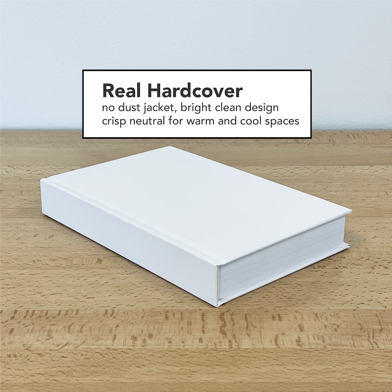May include: A white hardcover book with the text "Real Hardcover" on the front cover. The text below reads "no dust jacket, bright clean design crisp neutral for warm and cool spaces".