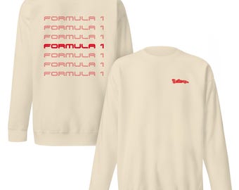Peut inclure: Un sweat-shirt crème avec le texte "FORMULA 1" répété en rouge et rose au dos. Le devant du sweat-shirt présente une petite image rouge et blanche d'une voiture de course.