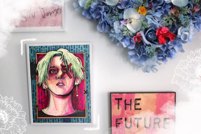 May include: A framed illustration of a person with green hair and a red X over their eye. The background is a vibrant pink and blue with stars. The frame is white with a blue and green pattern. There is a sign below that says "THE FUTURE" in black text on a pink and orange background.