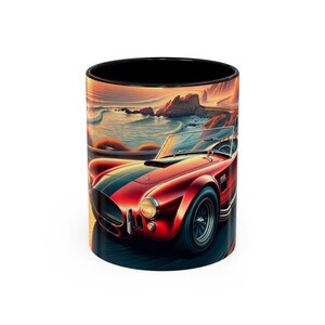 May include: A red and black ceramic mug with a sunset scene and a red vintage sports car driving on a winding road.