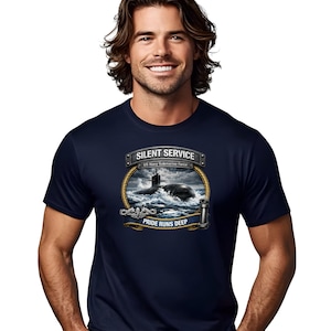 Könnte beinhalten: Marineblaues T-Shirt mit detaillierter Grafik eines U-Boots auf See, mit dem Text "SILENT SERVICE" und "PRIDE RUNS DEEP". Das Design beinhaltet einen Seilrand und einen Leuchtturm. Das T-Shirt hat einen klassischen Rundhalsausschnitt.