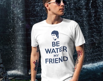 May include: White t-shirt with a blue image of Bruce Lee and the text "Be Water My Friend".