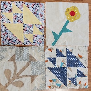 May include: Four square fabric quilt blocks featuring diverse patterns and designs. One block has a yellow geometric star on a floral background, another a yellow flower with a red center, a third a beige leaf motif, and the last a blue polka dot star.