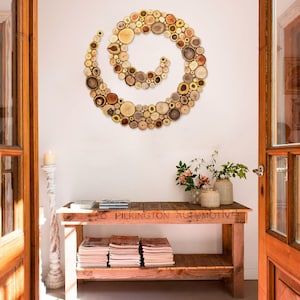 It is an original artwork in the form of a spiral on a rustic sideboard. The spiral wall art is created with slices of tree branches and has great beauty and personality due to the shape and shades of the slices. Sizes: 20, 24, 28, 32, 36, 40 in.