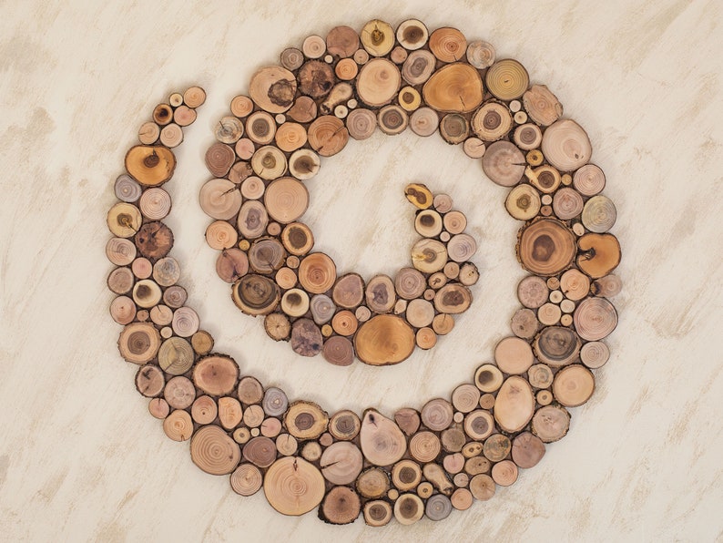 It is an original artwork in the form of a spiral on the wall. The wood spiral is handmade from slices of Mediterranean tree branches and has great beauty and personality due to the shape and shades of the slices. Sizes: 20, 24, 28, 32, 36, 40 in.