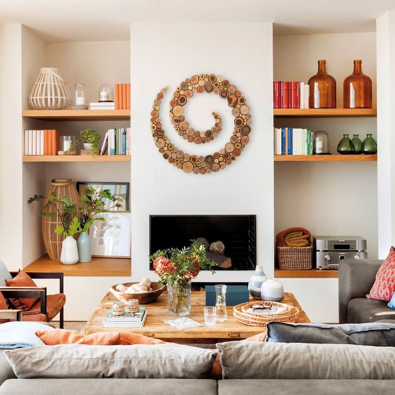 It is a spiral-shaped work of art located in a living room above the fireplace. The artwork is handmade from slices of tree branches and has great beauty and personality due to the shape and shades of the slices. Sizes: 20, 24, 28, 32, 36, 40 in.