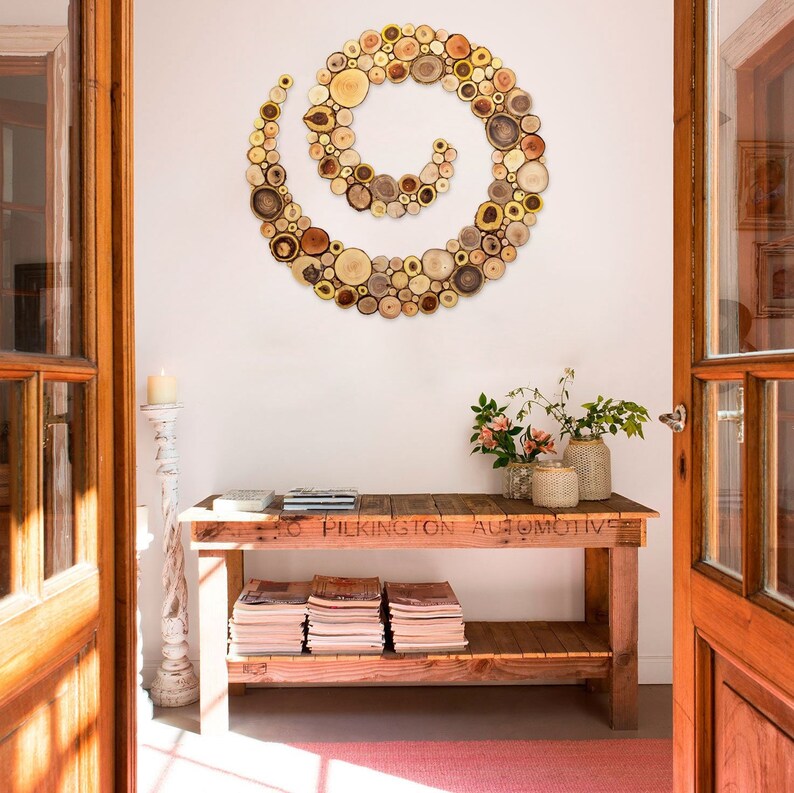 It is an original artwork in the form of a spiral on a rustic sideboard. The spiral wall art is created with slices of tree branches and has great beauty and personality due to the shape and shades of the slices. Sizes: 20, 24, 28, 32, 36, 40 in.