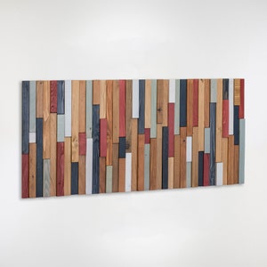 This artwork is made with reclaimed wood. 
The shades show off the beauty of the wood grain. The combination of cold and warm colours and the different geometric pieces, makes it a very balanced artwork.