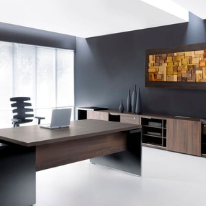 The artwork is placed on the wall of a modern and elegant office. Its dimensions are: 48 x 24 inches. The interior has a relief composition of recycled wood pieces of different shapes and shades. Around it is a narrow area painted in dark brown.