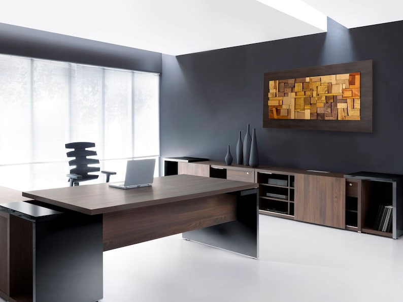 The artwork is placed on the wall of a modern and elegant office. Its dimensions are: 48 x 24 inches. The interior has a relief composition of recycled wood pieces of different shapes and shades. Around it is a narrow area painted in dark brown.