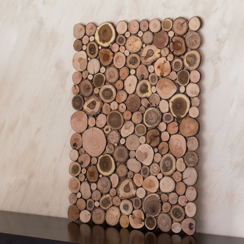 The side image shows a decorative wall panel in vertical format made up of slices of wood from tree branches in which a beautiful mosaic of shapes and tones can be seen. This ecological artwork can be personalised.