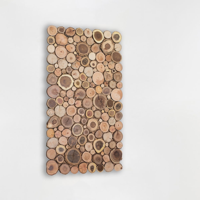The side image shows a decorative wall panel in vertical format made up of slices of wood from tree branches in which a beautiful mosaic of shapes and tones can be seen. This ecological artwork can be personalised.