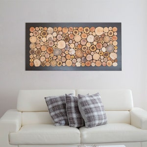Puede incluir: Una pieza de arte mural rectangular que presenta un mosaico denso de rodajas de madera natural en varios tonos de marr&oacute;n, bronceado y crema. Los segmentos circulares de madera est&aacute;n dispuestos estrechamente sobre un marco rectangular oscuro.