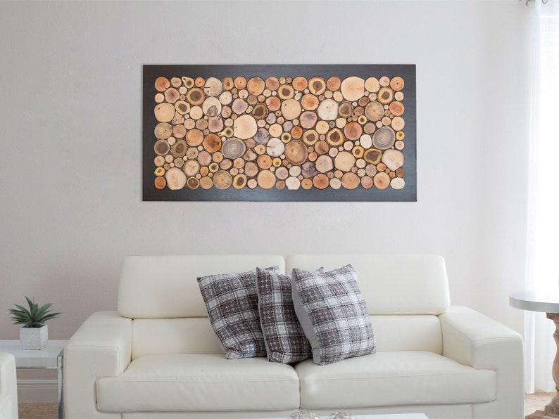Puede incluir: Una pieza de arte mural rectangular que presenta un mosaico denso de rodajas de madera natural en varios tonos de marr&oacute;n, bronceado y crema. Los segmentos circulares de madera est&aacute;n dispuestos estrechamente sobre un marco rectangular oscuro.