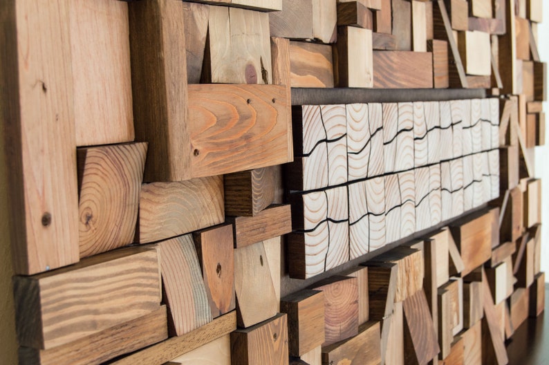 The side image shows in detail the volume and shape of the recycled wood pieces that make up this horizontal wall sculpture, as well as their beautiful imperfections. This eco-friendly piece is painted in warm tones. Dimensions: 48 x 24 in.