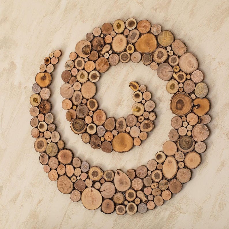 It is an original artwork in the form of a spiral on the wall. The artwork is handmade from slices of Mediterranean tree branches and has great beauty and personality due to the shape and shades of the slices. Sizes: 20, 24, 28, 32, 36, 40 in.