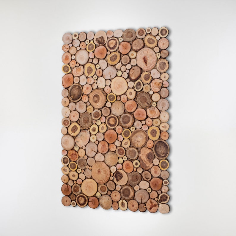 The side image shows a decorative wall panel in vertical format made up of slices of wood from tree branches in which a beautiful mosaic of shapes and tones can be seen. Dimensions: 39 x 26 inches. This ecological artwork can be personalised.