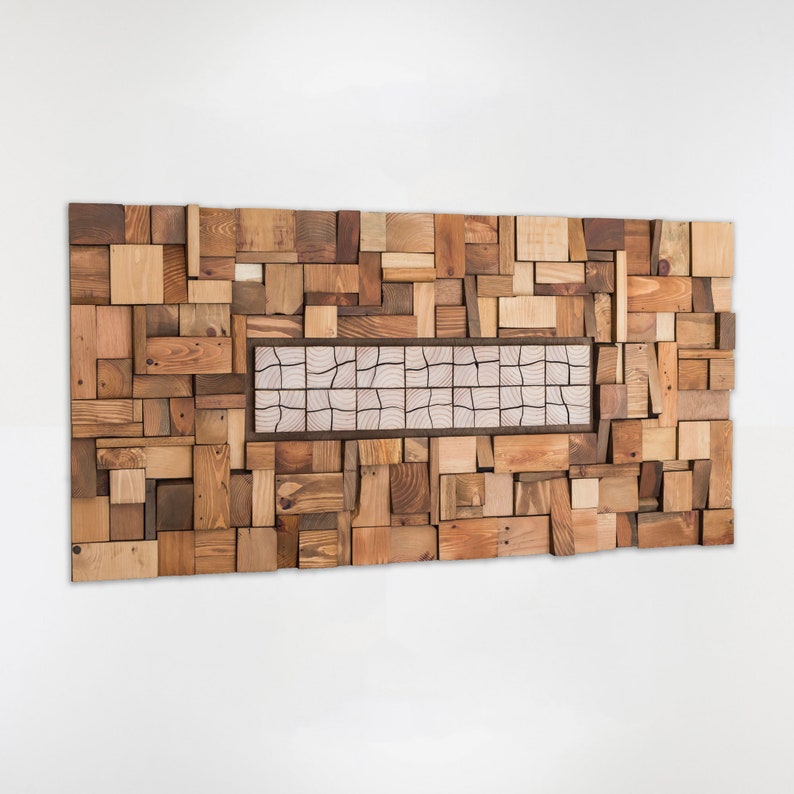 Side image. The wooden wall sculpture is created with recycled wood pieces of different shapes and sizes and painted in warm tones. The central part is a very original mosaic and has different pieces from the rest. Dimensions: 48 x 24 in.