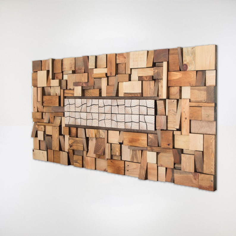 Side image. The wooden wall art for living room is created with recycled wood pieces of different shapes and sizes and painted in warm tones. The central part is a very original mosaic and has different pieces from the rest. Dimensions: 48 x 24 in.