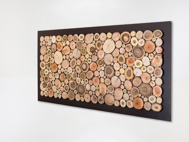 Side image. This is a beautiful and elegant wall sculpture created from slices of tree branches of different shades. The slices take up almost the entire surface and the 2 in exterior is painted dark brown. Size: 48 x 24 in. Can be personalised