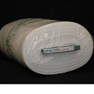 Op de afbeelding: Een rol witte stof verpakt in doorzichtig plastic. De stof is strak opgerold en lijkt van een gemiddeld gewicht te zijn. Een label met het woord "pellon" is zichtbaar op de rol. De achtergrond is zwart.