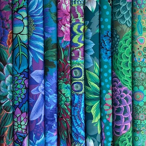 Könnte beinhalten: Eine Sammlung gerollter Stoffballen mit lebendigen Blumenmustern. Die Designs zeigen große Blüten in Blau-, Lila-, Grün- und Türkistönen. Der Stoff scheint Baumwolle oder ein ähnliches Material zu sein, das sich zum Quilten oder für Kleidung eignet.