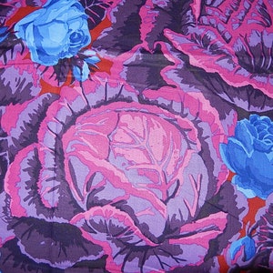 May include: A fabric with a floral pattern featuring large cabbage roses and blue roses. The cabbage roses are in shades of purple and pink, with dark purple leaves. The blue roses are a bright contrast against the other colors.