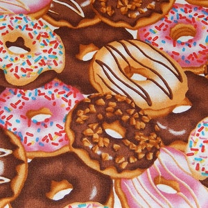 May include: A fabric pattern featuring a dense arrangement of various donuts. The design includes chocolate-frosted donuts with sprinkles, pink-frosted donuts with sprinkles, glazed donuts with chocolate drizzles, and donuts topped with nuts.